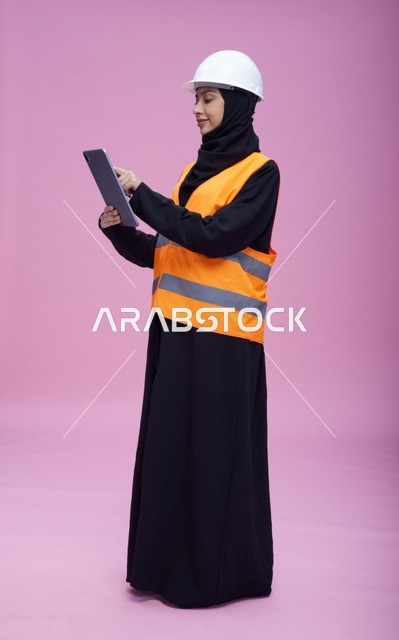 Saudi Female Engineer Using Tablet on Pink Background