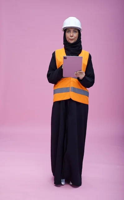 Saudi Female Engineer Using Tablet on Pink Background