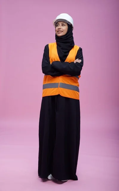 مهندسة سعودية بملابس السلامة على خلفية وردية