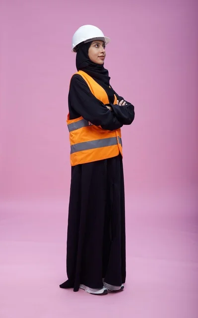 مهندسة سعودية بملابس السلامة على خلفية وردية