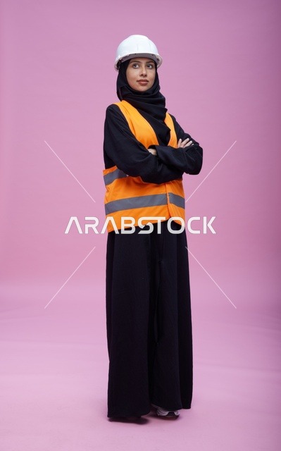 مهندسة سعودية بملابس السلامة خلفية وردية