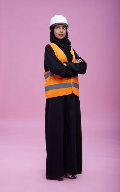 مهندسة سعودية بملابس السلامة خلفية وردية