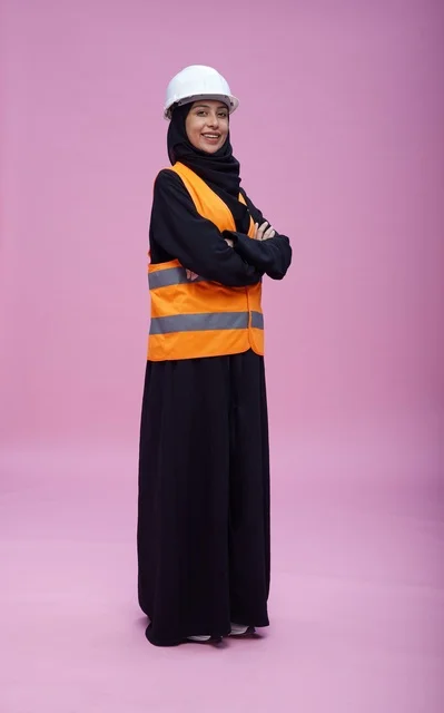 مهندسة سعودية بملابس السلامة أمام خلفية وردية