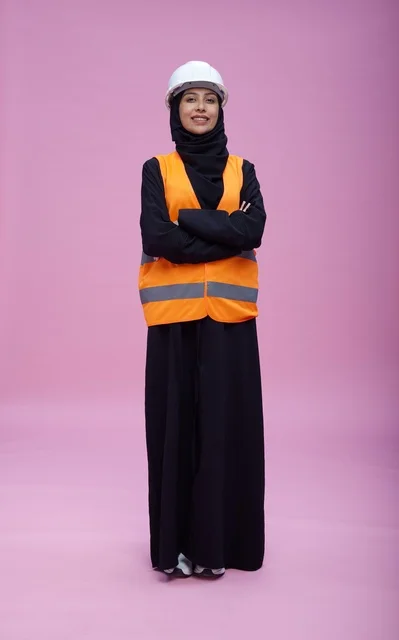 مهندسة سعودية بملابس السلامة خلفية وردية
