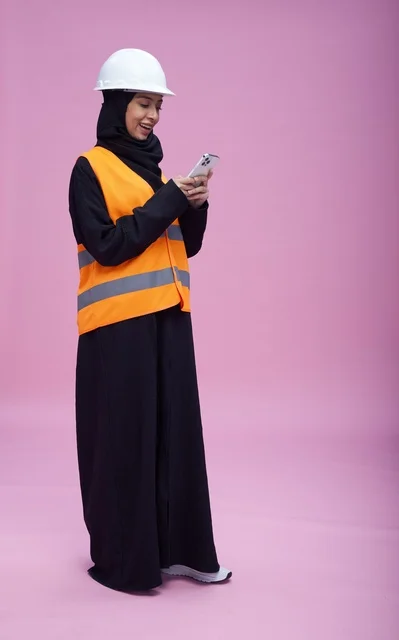 Saudi Female Engineer Using Smartphone on Pink Background