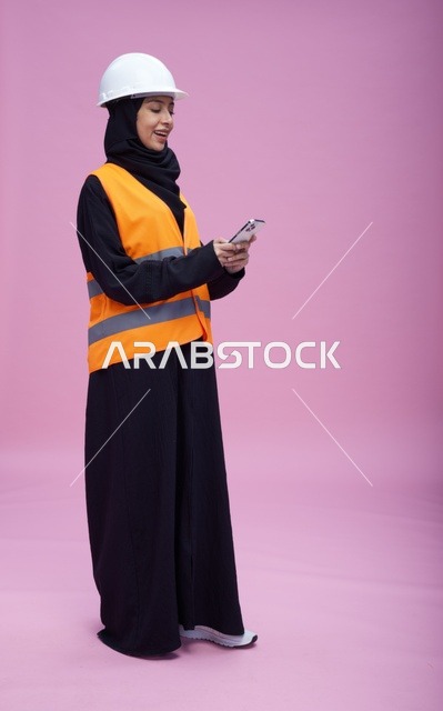Saudi Female Engineer Using Smartphone on Pink Background