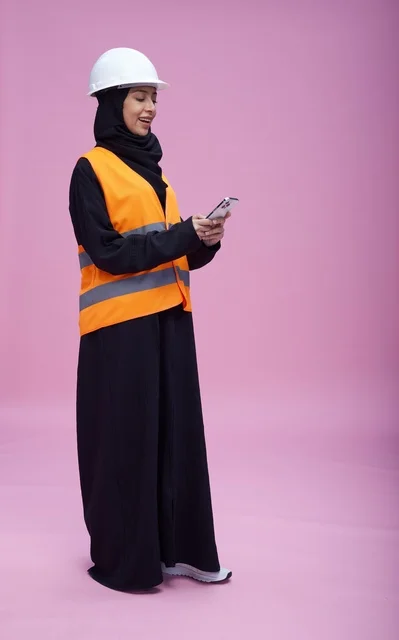 Saudi Female Engineer Using Smartphone on Pink Background