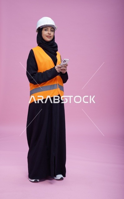 Saudi Female Engineer with Smartphone on Pink Background