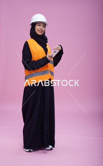 Saudi Female Engineer with Smartphone on Pink Background