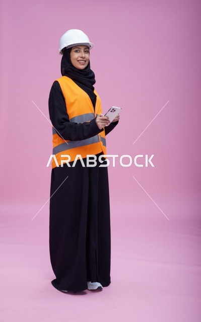 Saudi Female Engineer Using Smartphone on Pink Background