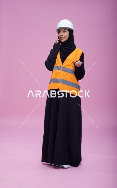 مهندسة سعودية تتحدث بالهاتف بسترة السلامة