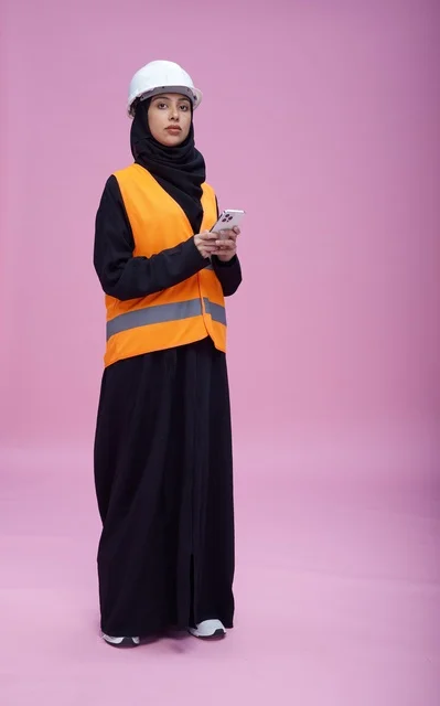 Saudi Female Engineer with Smartphone on Pink Background