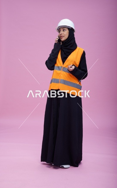 مهندسة سعودية تتحدث بالهاتف بمعدات السلامة