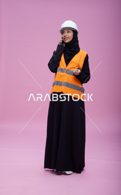 مهندسة سعودية تتحدث عبر الهاتف بخلفية وردية