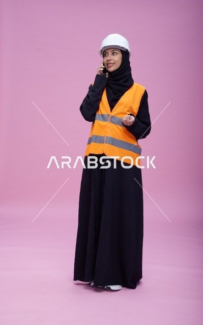 مهندسة سعودية بسترة السلامة تتحدث عبر الهاتف