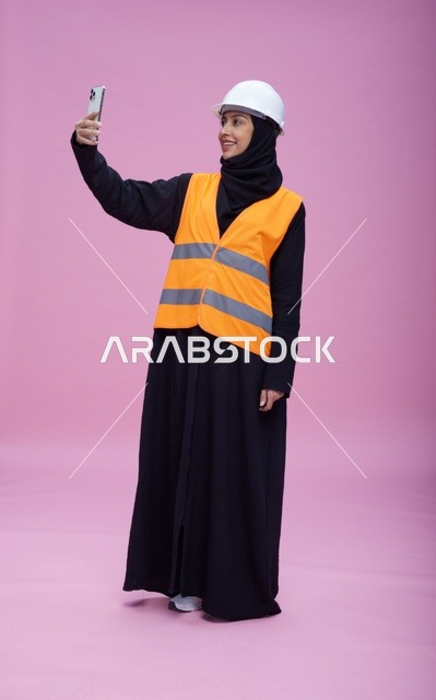 مهندسة سعودية تلتقط سيلفي بالهاتف الذكي بخلفية وردية