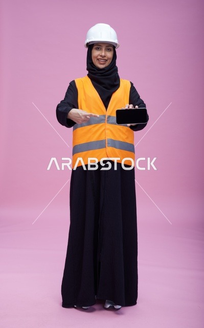 مهندسة سعودية تمسك هاتف ذكي بشاشة سوداء