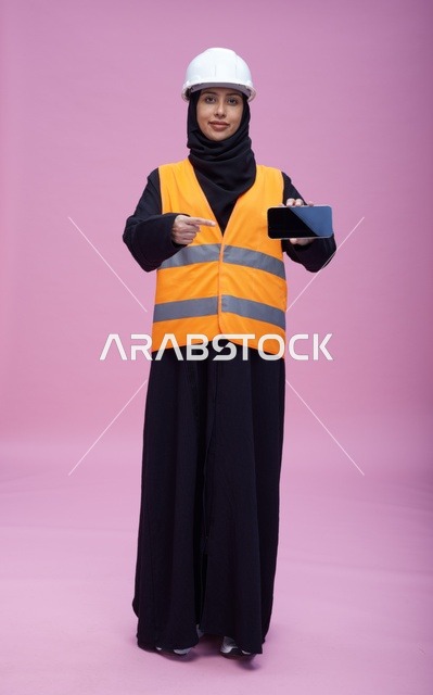 مهندسة سعودية تحمل هاتف ذكي بخلفية وردية