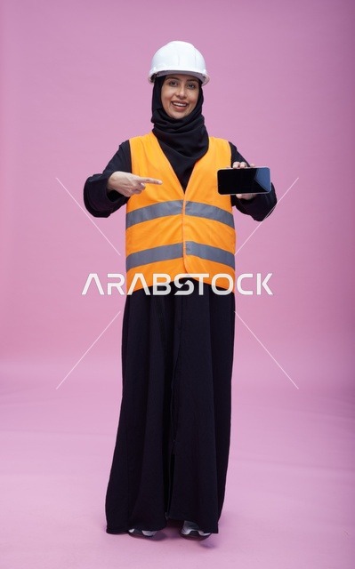 مهندسة سعودية تحمل هاتف ذكي بشاشة فارغة