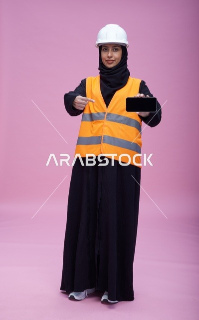 مهندسة سعودية تحمل هاتف ذكي بشاشة فارغة