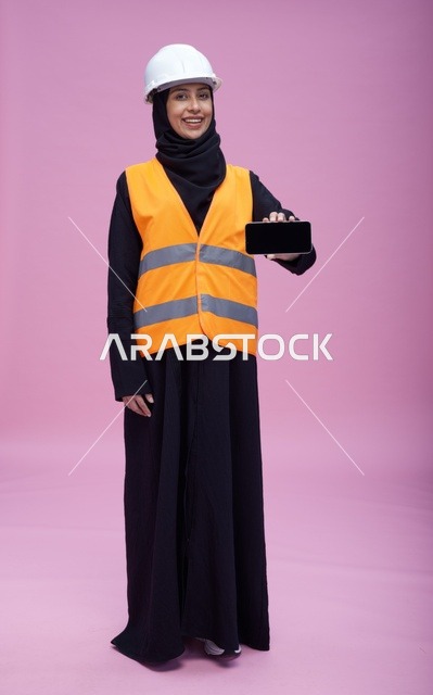 مهندسة سعودية تحمل هاتف ذكي بشاشة فارغة