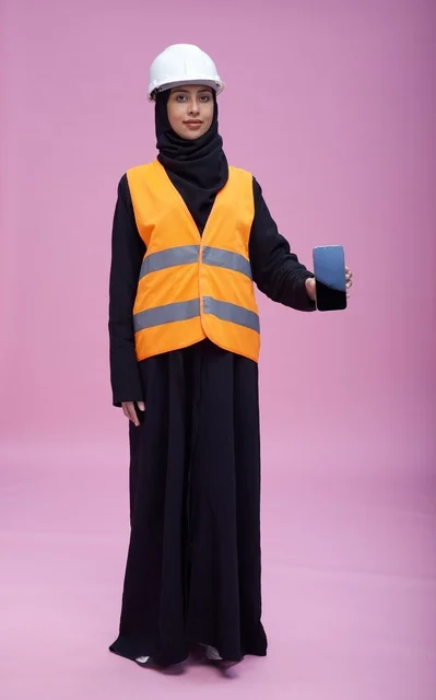 مهندسة سعودية تحمل هاتف ذكي بخلفية وردية مهندسة سعودية تحمل هاتف ذكي بخلفية وردية