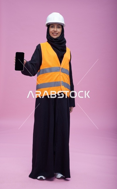 مهندسة سعودية تحمل هاتف ذكي بشاشة فارغة