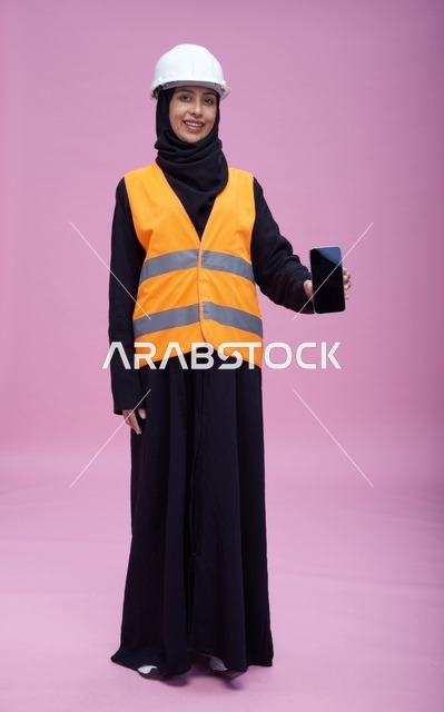 Saudi Female Engineer Holding Smartphone on Pink Background