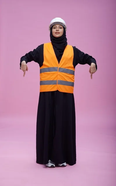 مهندسة سعودية بملابس السلامة تشير لأسفل