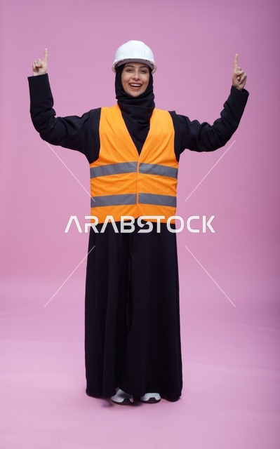 مهندسة سعودية بملابس السلامة بخلفية وردية