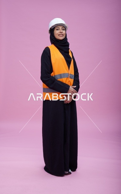 مهندسة سعودية بملابس السلامة على خلفية وردية