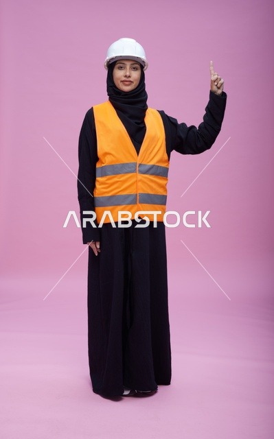 Saudi Female Engineer in Safety Vest Pointing Up