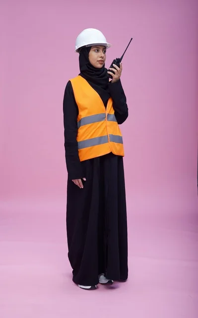 Saudi Female Engineer with Walkie-Talkie on Pink Background