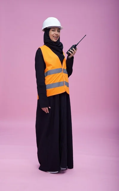 مهندسة سعودية مع جهاز لاسلكي وخوذة سلامة