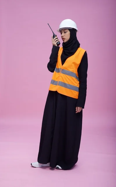 Saudi Female Engineer with Walkie-Talkie on Pink Background