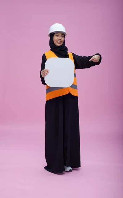 مهندسة سعودية تحمل لوحة بيضاء فارغة بخلفية وردية مهندسة سعودية تحمل لوحة بيضاء فارغة بخلفية وردية