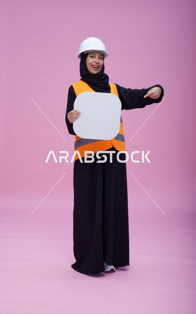 مهندسة سعودية تحمل لوحة بيضاء فارغة بخلفية وردية
