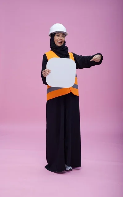 مهندسة سعودية تحمل لوحة بيضاء فارغة بخلفية وردية