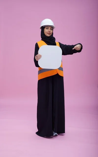 مهندسة سعودية تحمل لوحة بيضاء فارغة بخلفية وردية