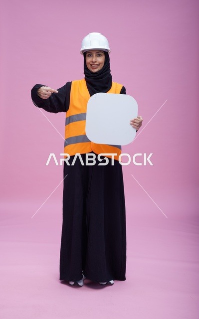 مهندسة سعودية تحمل لوحة فارغة خلفية وردية