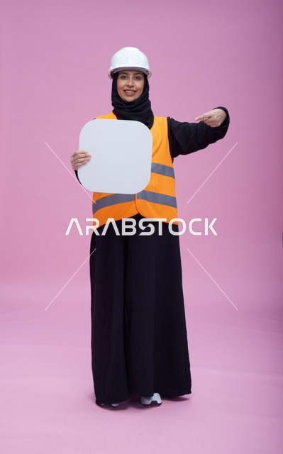 مهندسة سعودية تحمل لوحة بيضاء فارغة في الاستوديو