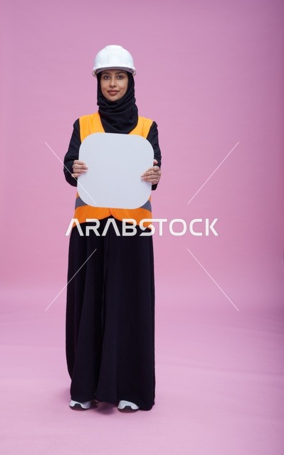 مهندسة سعودية تحمل لوحة بيضاء فارغة بخلفية وردية