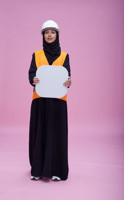 مهندسة سعودية تحمل لوحة فارغة أمام خلفية وردية