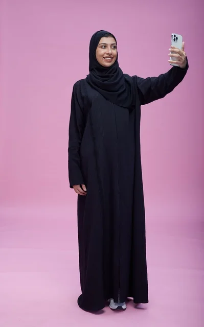 Saudi Woman Taking Selfie with Smartphone on Pink