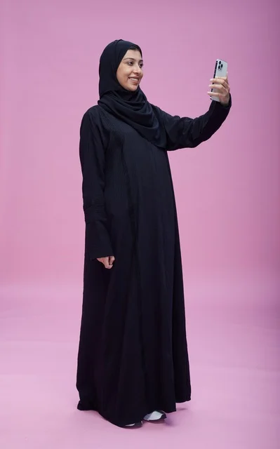 Saudi Woman Taking Smartphone Selfie on Pink Background