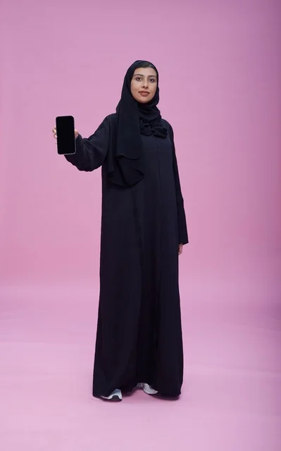 Saudi Woman in Abaya Holding Blank Smartphone Screen