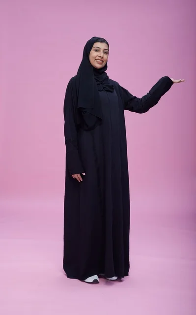 امرأة سعودية بالعباءة تقدم عرضاً في الاستوديو