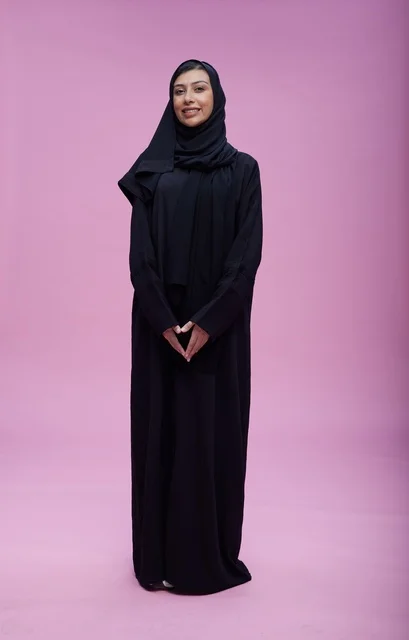 Saudi Woman in Abaya Standing Pink Studio Portrait