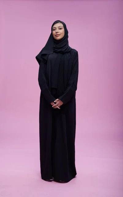 Saudi Woman in Black Abaya on Pink Studio Background