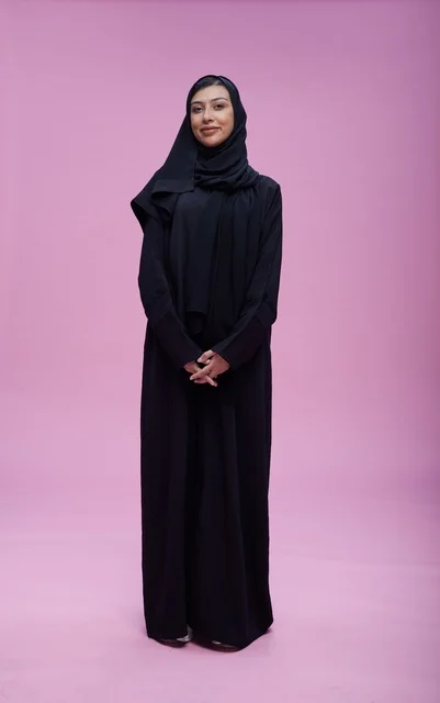 Saudi Woman in Black Abaya on Pink Background